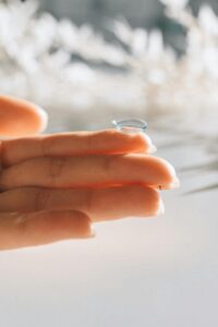 Lentille souple posée sur l'index d'une main féminine européenne