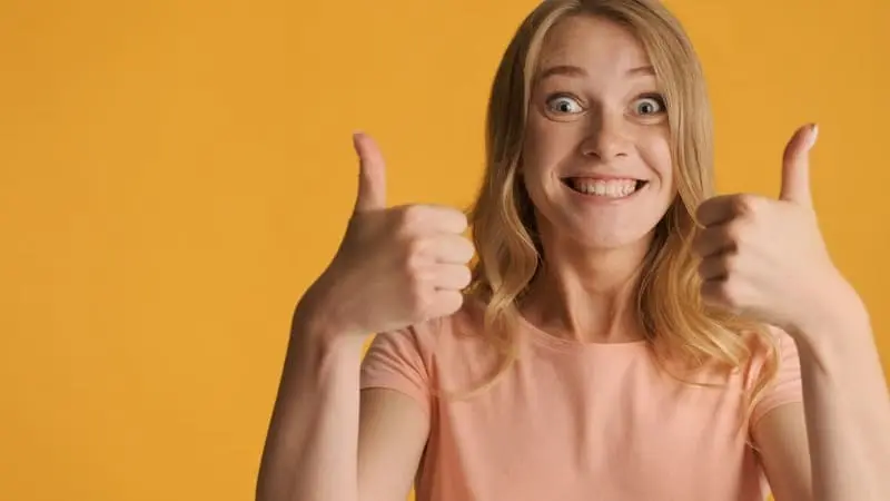 Jeune femme blonde souriante, les deux pouces levés – illustration de la garantie Privilège chez VISION BORDELAISE